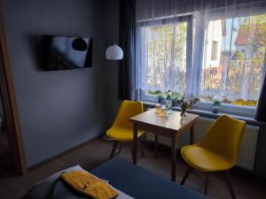 a room with two yellow chairs and a table and a window at Gästehaus Müller in Hohenleipisch