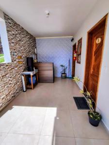 a hallway with a door and a brick wall at Chalés e suítes lima in Monte Verde