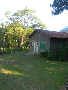 a small house in a yard next to a tree at Bella Serra in Iporanga
