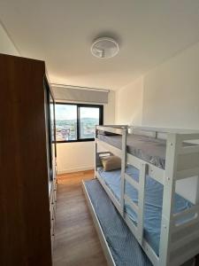 a room with two bunk beds and a window at Apê completo 2 quartos 300m da praia15min Beto Carreiro in Piçarras