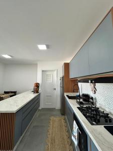 a kitchen with a stove and a counter top at Apê completo 2 quartos 300m da praia15min Beto Carreiro in Piçarras +7 photos