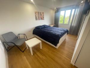 a bedroom with a bed and a table and a window at Olivia in Argenteuil