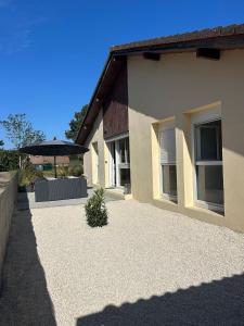 a house with a patio and an umbrella at Maison de jacque in Mimizan