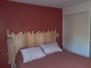 a bedroom with a bed with a wooden headboard at Maison de jacque in Mimizan