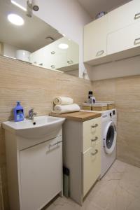 a kitchen with a sink and a washing machine at Apartament in Kętrzyn