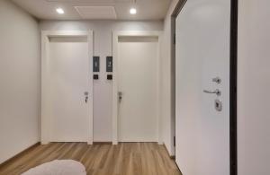 a hallway with two white doors and a rug at Monolocale 1 - via Sassi, Lecco in Lecco