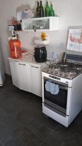 a kitchen with a stove and a counter with bottles at Pousada Cantinho da Idná in Uberlândia