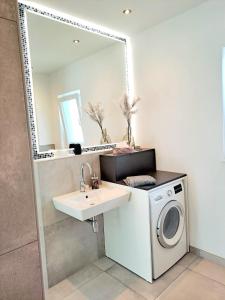a bathroom with a washing machine and a sink at Penthouse Vue Panoramique in Mechernich