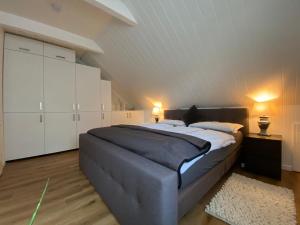 a bedroom with a large bed with white cabinets at Auszeitwohnung in Lage