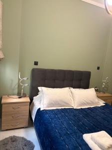 a bedroom with a bed with a blue comforter at Stone house 48 m in Acharnes