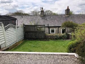 an old house with a garden in front of it at 2, The Lodge, Tideswell in Tideswell