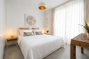 a white bedroom with a large bed and a window at Marchese 25 Apartments in Bari