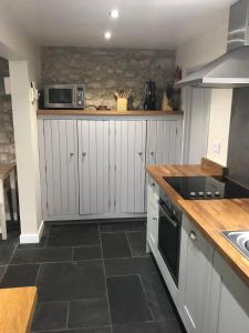 a kitchen with white cabinets and a counter top at 2, The Lodge, Tideswell in Tideswell +4 photos