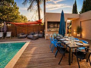 a patio with a table and chairs next to a pool at Maison ROMIA in Fréjus