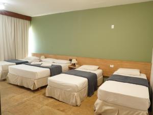 a group of four beds in a room at HANNA Marina's Palace Hotel in Florianópolis