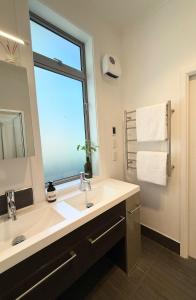a bathroom with a large sink and a window at Home Inn Timaru in Timaru +12 photos