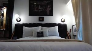 a bedroom with a bed with a black headboard and white pillows at MG suite 23 in Beausoleil