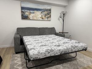 a bed in a room with a couch and a painting at Vinash Luxury Suite in Edmonton +37 photos