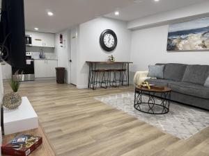 a living room with a couch and a clock on the wall at Vinash Luxury Suite in Edmonton