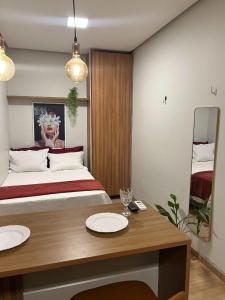 a bedroom with a bed and a table with two plates on it at Hospedagem Construgram in Itaituba