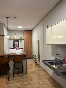 a kitchen with a sink and a counter with chairs at Hospedagem Construgram in Itaituba