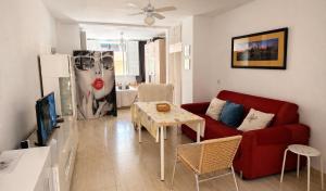 a living room with a red couch and a table at Casa Angeles in Castell de Ferro