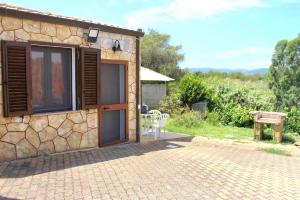 a stone house with a patio and a table at La Rosa dei Venti in Alghero