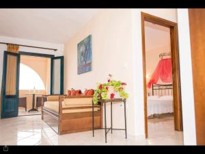 a living room with a bed and a table with a table sidx sidx at Archipelagos Apartments in Arkasa