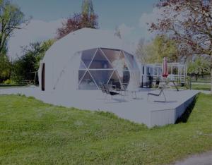 a dome tent in a field with a table and chairs at Nuit Insolite dôme Reinette tout confort in Châtenois