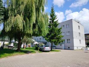 a car parked in front of a white building at 208 Apartment Ania in Koszalin