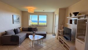 a living room with a couch and a tv at Meeresrauschen in Fehmarn