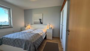 a bedroom with a bed with two night stands and two lamps at Meeresrauschen in Fehmarn