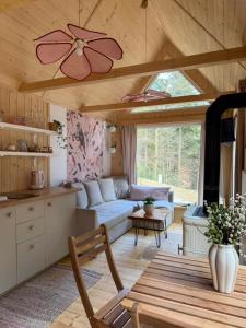a living room with a couch and a table at Tiny house nad potokiem in Sidzina