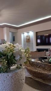 a living room with two vases with flowers on a table at Speranza's Sweet Home, Family House with Garden in Vrontantos in Vrontádos