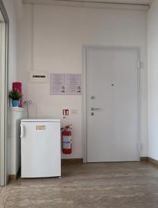 a white refrigerator and a door in a room at CMBYN Stanza in Casa Condivisa e Bici Gratis in Crema