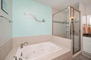 a bathroom with a bath tub with a glass shower at Salty Girl by Oak Island Accommodations in Oak Island