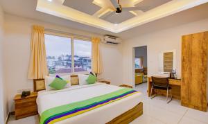 a bedroom with a bed and a desk and a window at casa Verde Kochi in Cochin