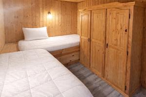 a small room with two beds and a cabinet at Feriensiedlung Schwalbennest - Bungalows in Dranske