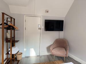 a living room with a chair and a flat screen tv at Soho Room n4 in London
