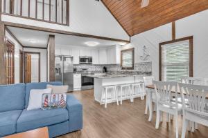 a living room with a blue couch and a kitchen at Salty Dawg by Oak Island Accommodations in Oak Island