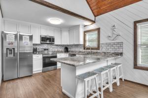 a kitchen with white cabinets and stainless steel appliances at Salty Dawg by Oak Island Accommodations in Oak Island