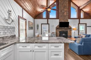 a kitchen and living room with a blue couch at Salty Dawg by Oak Island Accommodations in Oak Island +50 photos