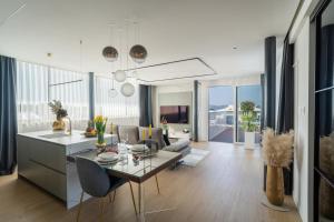a kitchen and living room with a table and chairs at Dedaj Resort - Penthouse Auri in Zadar