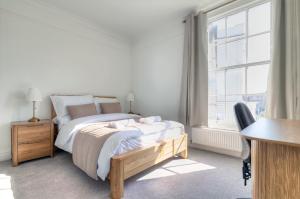 a bedroom with a bed and a desk and a window at 7 Clarendon Place in Maidstone