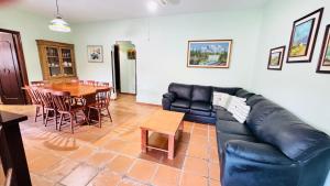a living room with a black leather couch and a table at Casa Lar Doce Mar Juquehy in São Sebastião +16 photos