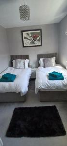 a bedroom with two beds and a rug at Highwood mews in Cleethorpes