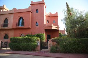 a red building with a gate in front of it at villa Marrakech 3chambre in Marrakesh