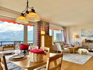 a living room with a table and chairs and mountains at Sunny Alpine Apartment - 180 View in Lens
