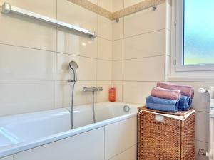 a bathroom with a bath tub and a basket with towels at Sunny Alpine Apartment - 180 View in Lens +31 photos