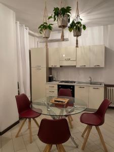 a kitchen with a glass table and red chairs at Borghaus Iseo in Iseo